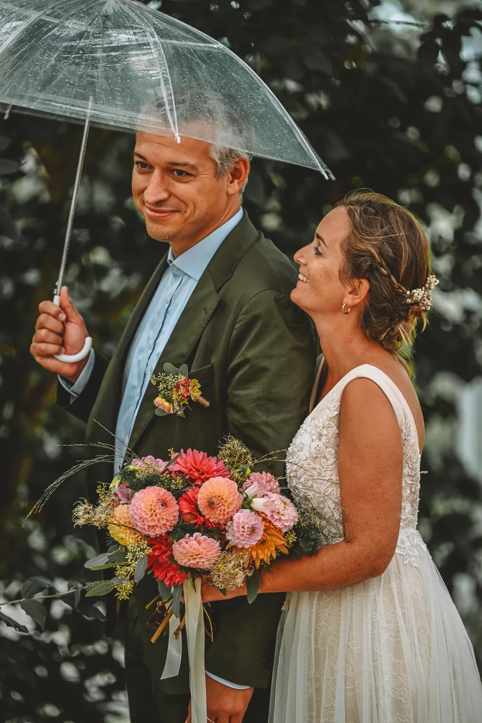 Bruidspaar onder een paraplu in de regen
