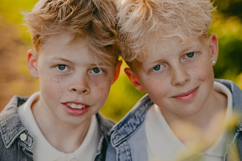 Twee broers met sproeten, wang aan wang in de zon