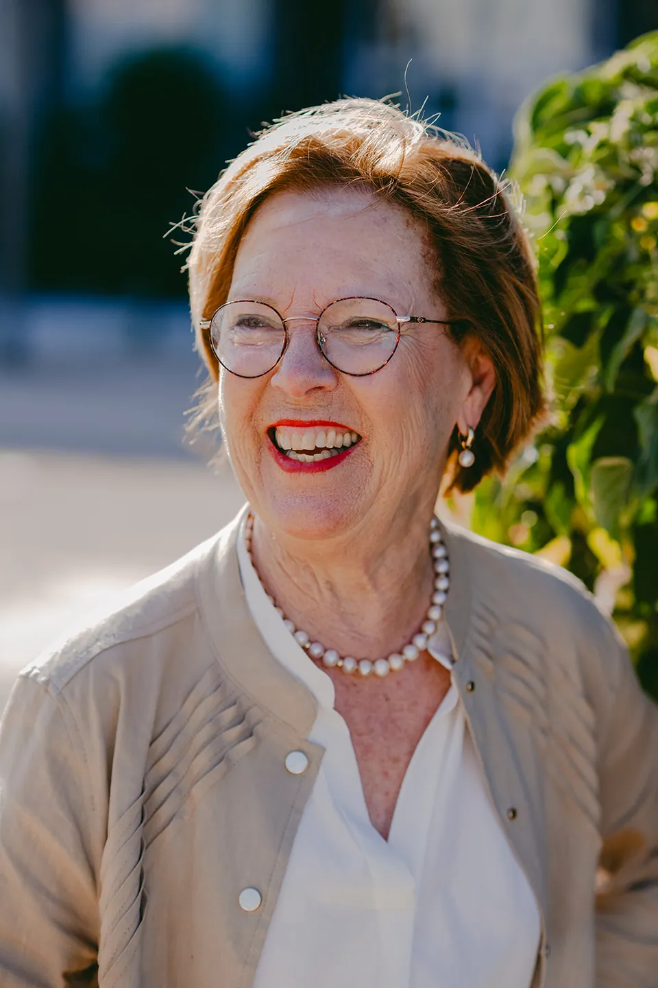 Oma lacht stralend, met haar parelketting in de zon